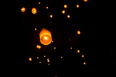 Low angle view of illuminated lantern against black sky
