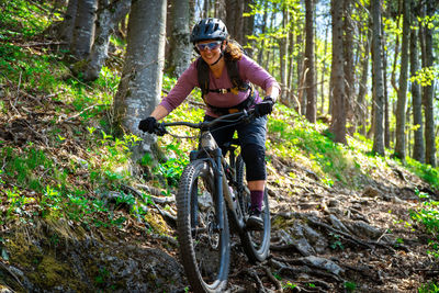 Woman mountain biking on footpath in forest, salzburg, austria