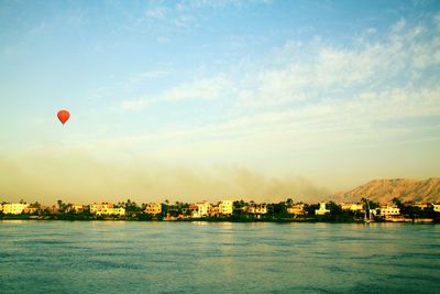 Scenic view of sea against cityscape