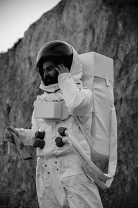 Male astronaut standing against rock formation