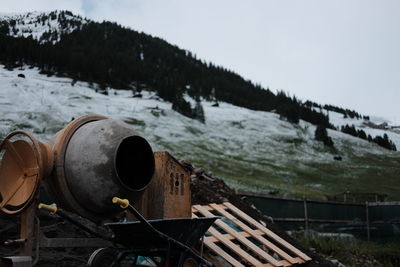 Machinery on field against sky during winter