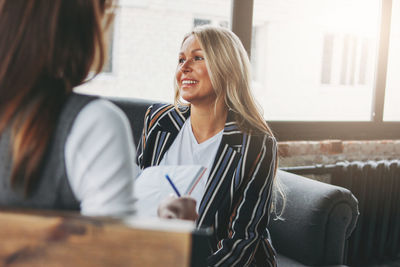 Smiling woman sitting on chair at home