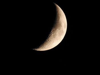 Low angle view of half moon against sky at night