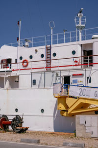 Boats moored at harbor against clear sky