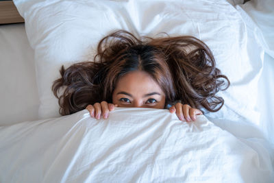 Portrait of woman lying down on bed