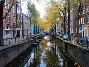 Canal amidst buildings in city during rainy season