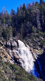 Scenic view of waterfall against sky