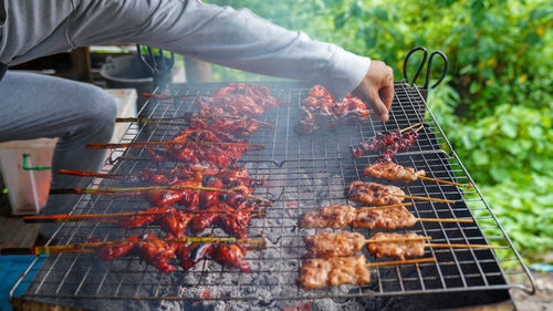 Person preparing food on barbecue grill