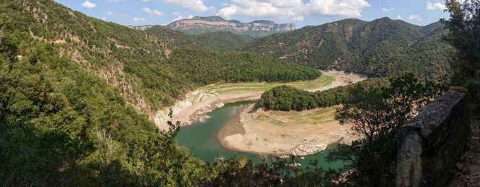 High angle view of river amidst mountains against sky