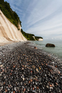 Pebbles on beach against sky