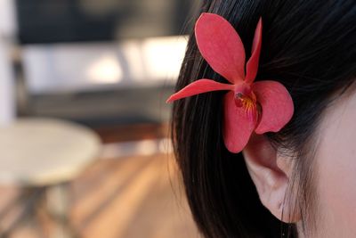 Close-up of woman with red flower