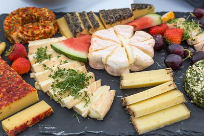 High angle view of various cheese served on stone tray