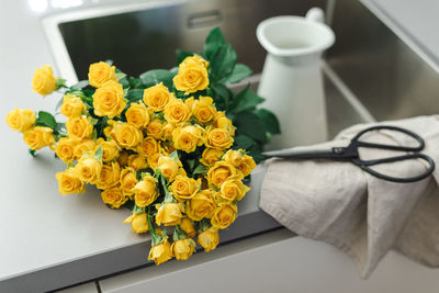 A bouquet of yellow garden roses in the kitchen sink.