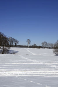 Snow covered land against clear sky