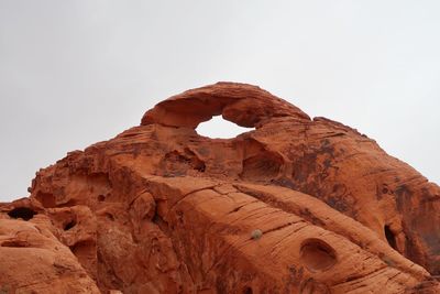 Large red rock sandstone formations and natural arch against the sky