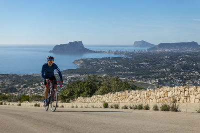 Rear view of man riding bicycle on mountain