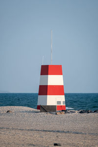 Flag on beach against clear sky