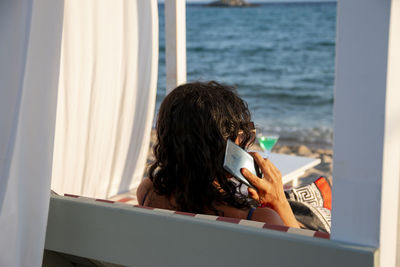 Entrepreneur woman working with a phone and a laptop on holidays in a tropical beach