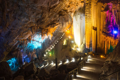 Low angle view of illuminated lighting equipment in cave