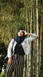 Woman standing against bamboos