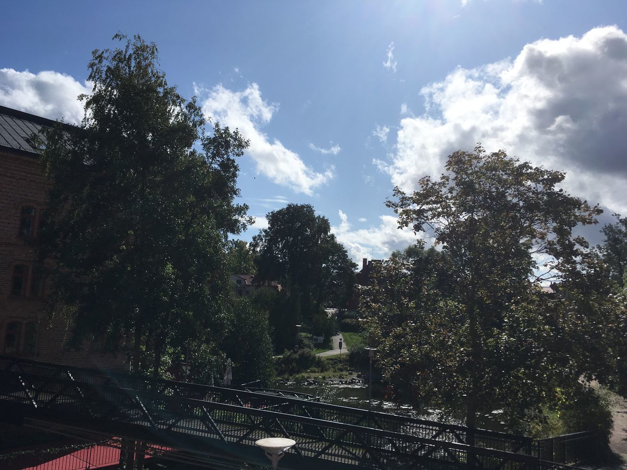 TREES BY BUILDING AGAINST SKY