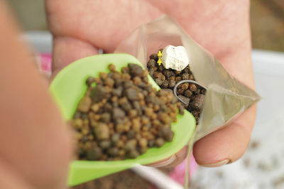 Cropped hands holding plastic bag with fish food