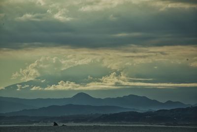 Scenic view of sea and mountains against sky