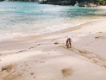 Girl playing on beach against sky