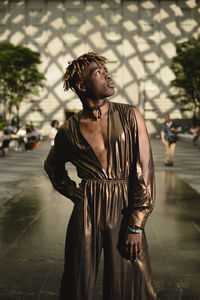 Young man looking away on street in city