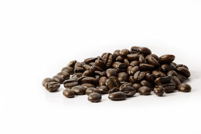 Close-up of roasted coffee beans against white background