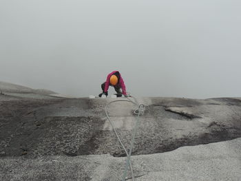 Rear view of man climbing on rock