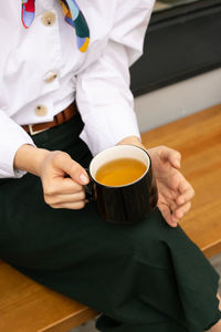 Midsection of woman holding coffee cup