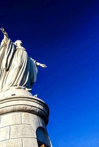 Low angle view of statue against blue sky