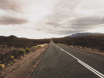 Road by mountain against sky