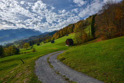 Scenic view of mountain road against cloudy sky