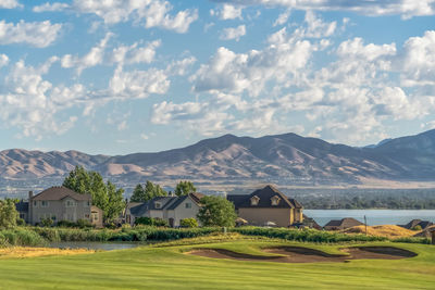 Scenic view of houses and mountains against sky