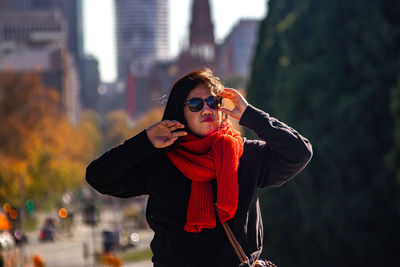 Portrait of young woman wearing sunglasses standing outdoors