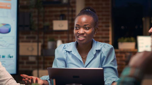 Portrait of young woman using laptop while sitting in cafe