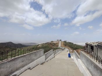 Panoramic view of road by city against sky