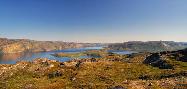 Scenic view of landscape and mountains against clear sky