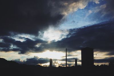 Silhouette of building against cloudy sky