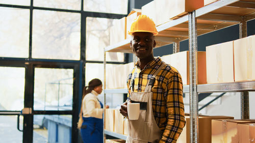 Portrait of young man standing in factory