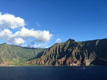 Scenic view of lake and mountains against blue sky