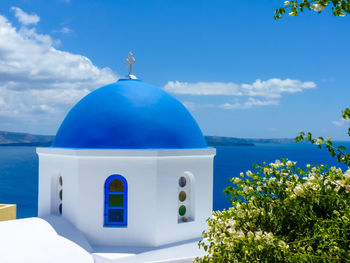 Built structure by sea against blue sky