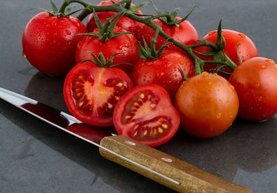 High angle view of cherry tomatoes and kitchen knife on table