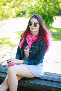 Beautiful young woman sitting at park