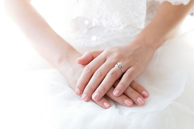 Midsection of bride wearing ring and pink nail polish