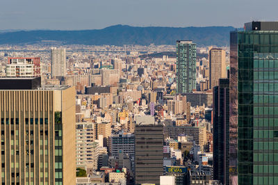 Aerial view of buildings in city against sky