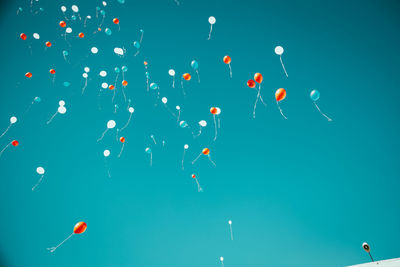 Low angle view of balloons flying in sky