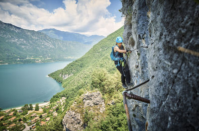 Woman wearing safety equipment climbing mountain